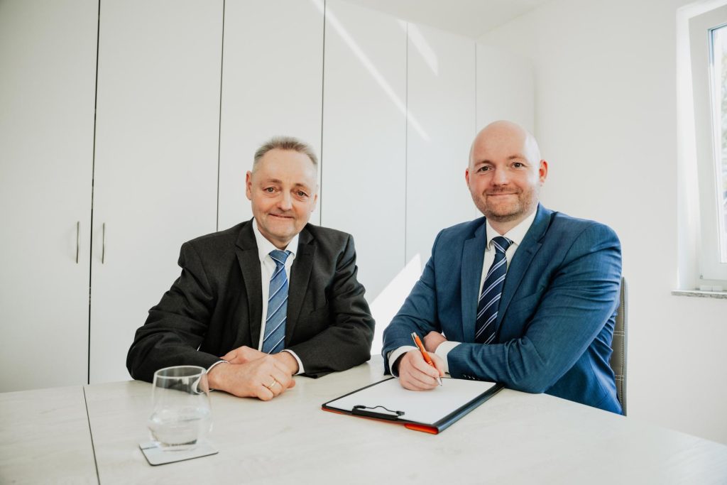 Matthias und Karsten Dumont im Beratungsgespräch am Schreibtisch